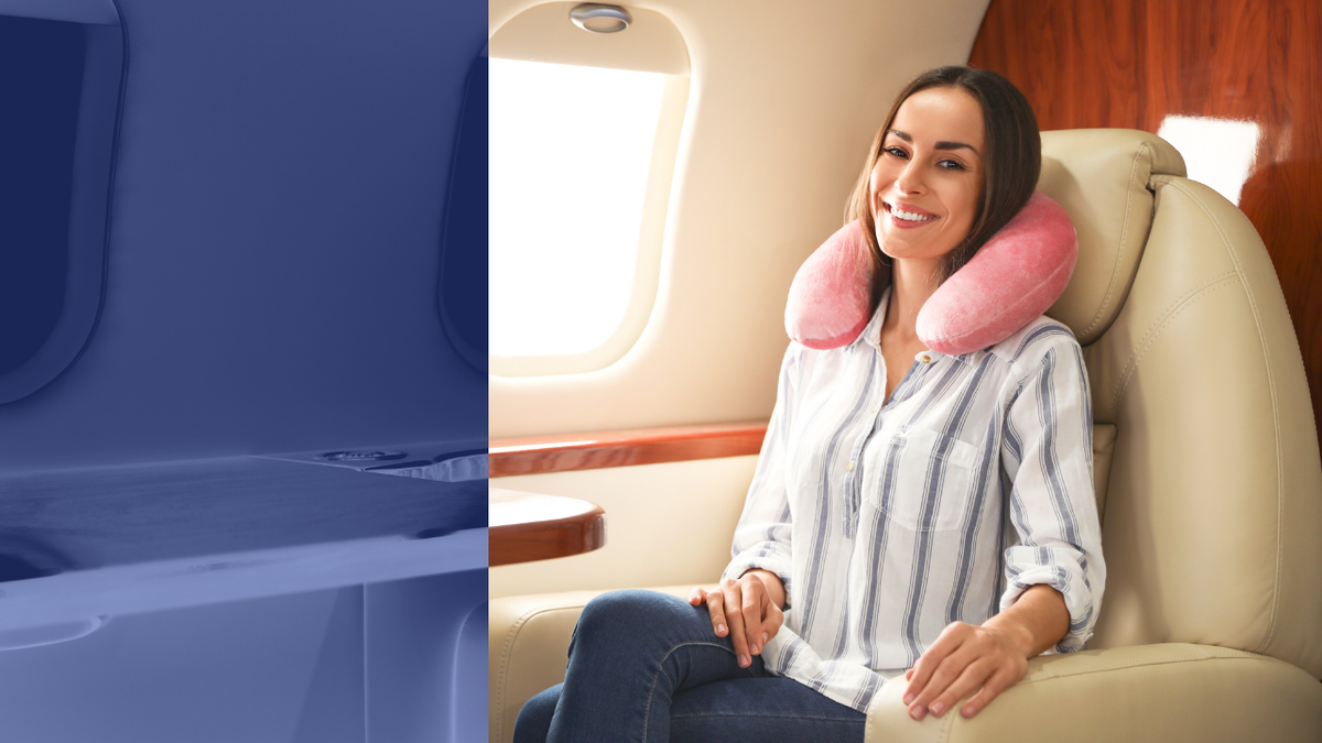 A smiling woman with a travel neck pillow seated comfortably on a plane, illustrating skincare comfort during flights.