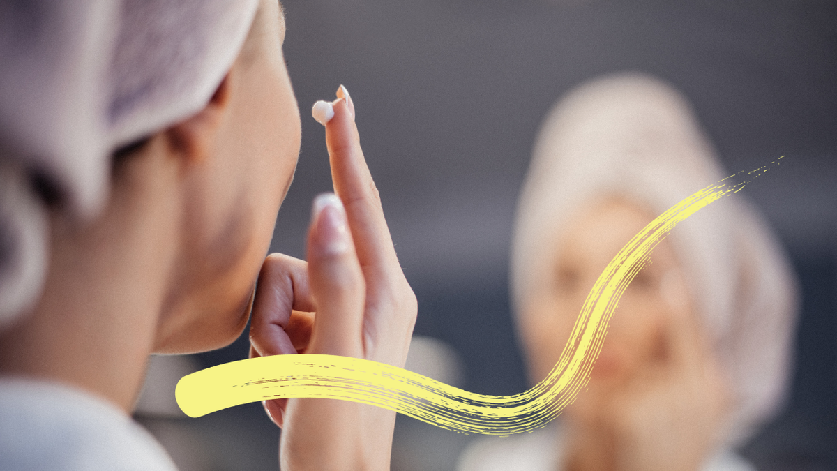 Luxury Face cream - A woman with a towel on her head applying cream to her face in front of a mirror, illustrating a luxurious skincare routine.